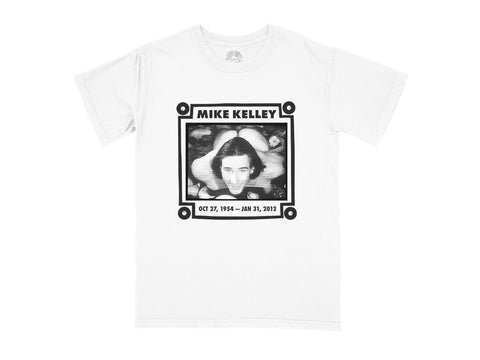 An image of a white t-shirt with "Mike Kelley" and "Oct 27, 1954-Jan 31, 2012" printed around an image of Mike Kelley