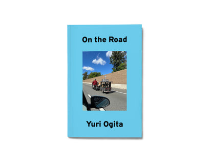 Image of a light blue book with a photo on the cover and the text "On the Road" "Yuri Ogita"
