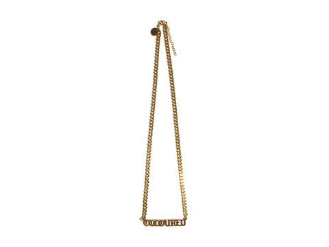 Image of gold "Coloured" nameplate necklace with 20-inch long chain on white background.