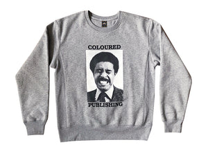 Image of a gray crewneck sweater with "Coloured" printed above a black and white image of a grimacing man, above the word "Publishing"